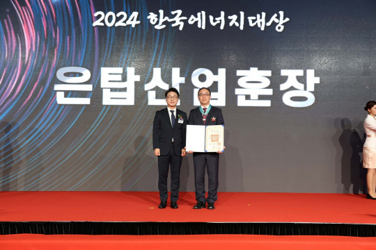 이상준(오른쪽) LS일렉트릭 자동화CIC COO가 19일 서울 태평로에 있는 더 플라자 호텔에서 열린 '2024 한국에너지대상' 시상식에서 이호현 산업통상자원부 에너지정책실장에게 훈장을 받은 뒤 기념촬영을 하고 있다. <LS일렉트릭 제공>